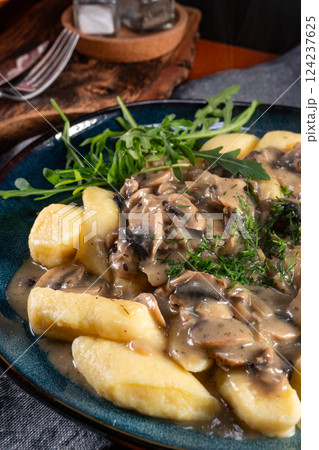 Homemade potato dumplings with mushrooms sauce and arugula. Homemade potato dumplings with mushrooms sauce and arugula. 124237625