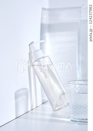 Bottle of cosmetic skin care product on white background with water reflections. Bottle of cosmetic skin care product on white background with water reflections. 124237862