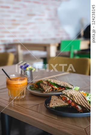 toasted vegetarian sandwich with mozzarella cheese and tomato and orange juice 124238145