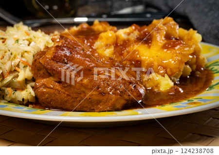 Braised pork ribs with spicy sauce served with mashed potatoes and salad. Braised pork ribs with spicy sauce served with mashed potatoes and salad. 124238708