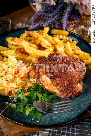 Crispy roasted chicken piece with french fries and salad. 124238797