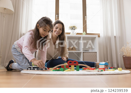 Happy young mommy little daughter playing toy train on floor 124239539