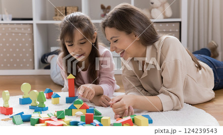 Loving mom playing with toy construction set with young daughter Loving mom playing with toy construction set with young daughter 124239543