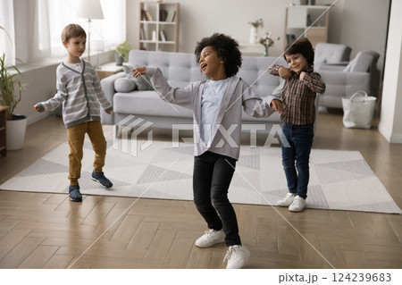 Adorable active little multiethnic brothers dance at living room together Adorable active little multiethnic brothers dance at living room together 124239683