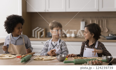Multiethnic team little boys brothers making cookies on kitchen table Multiethnic team little boys brothers making cookies on kitchen table 124239739