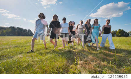 High school students embrace unity and friendship as they walk through a summer field holding hands High school students embrace unity and friendship as they walk through a summer field holding hands 124239983