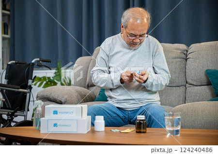 Asian worried senior man with medicine pills he read on see how to take pills before taking, old man buy herbal self cure Rx pill online from pharmacy, home isolation, Medical service concept Asian worried senior man with medicine pills he read on see how to take pills before taking, old man buy herbal self cure Rx pill online from pharmacy, home isolation, Medical service concept 124240486