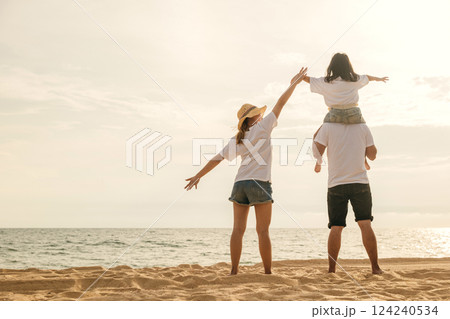 Happy family in holiday. Father, Mother and kids having fun together shoulder ride on summer beach, Parents carrying children on neck at beach, family is enjoying their summer time 124240534