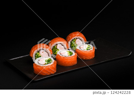 Delicious Fresh Salmon Sushi Rolls Presenting Exquisitely on a Black Background Delicious Fresh Salmon Sushi Rolls Presenting Exquisitely on a Black Background 124242228
