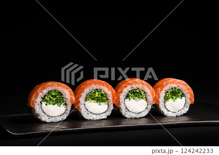 Delicious Fresh Salmon Sushi Rolls Presenting Exquisitely on a Black Background Delicious Fresh Salmon Sushi Rolls Presenting Exquisitely on a Black Background 124242233
