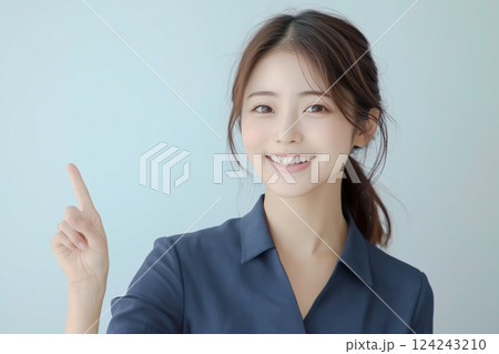 笑顔で上を指差す若い日本人女性 124243210