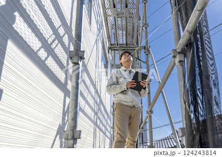 戸建て家屋の外壁修繕工事 作業状況を確認する現場監督 戸建て家屋の外壁修繕工事 作業状況を確認する現場監督 124243814