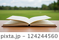 緑の中で机の上に広げられた本を読む 124244560