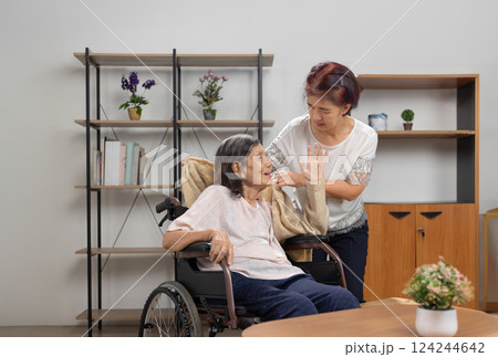 Daughter is helping dementia mother who is confused about getting dressed or changing clothes. Daughter is helping dementia mother who is confused about getting dressed or changing clothes. 124244642