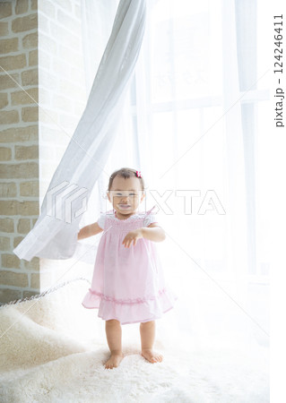 カーテンから顔を出す女の子 124246411