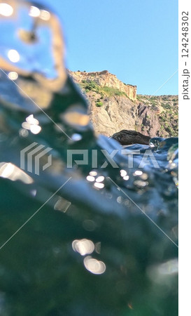 A body of water with a mountain in the background. 124248302