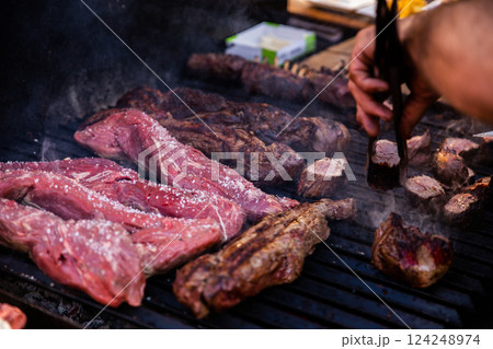 Some excellent pieces of Argentinian beef on a charcoal grill being prepared at open kitchen street food festival in Ljubljana, Slovenia 124248974