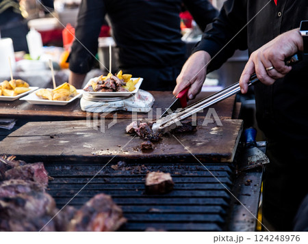 Some excellent pieces of Argentinian beef on a charcoal grill being prepared at open kitchen street food festival in Ljubljana, Slovenia Some excellent pieces of Argentinian beef on a charcoal grill being prepared at open kitchen street food festival in Ljubljana, Slovenia 124248976