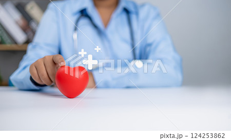 Healthcare worker and doctor service, Doctor showing a red heart and sing plus at hospital office, Medical technology concept, Health insurance concept, Health planning concept. 124253862