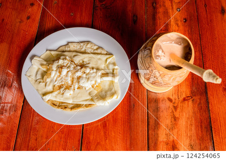 Delicious traditional Quesillo with cocoa drink. Quesillo plate with cocoa drink served on wooden table. Typical Nicaraguan food and drinks. 124254065
