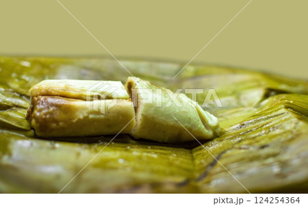 Stuffed tamale served in banana leaves. Close up of a traditional tamale on a banana leaf. Nicaraguan pisque tamale on banana leaf. Tamalpisque traditional Central American food 124254364
