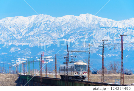 富山地方鉄道と雪の立山連峰 124254490