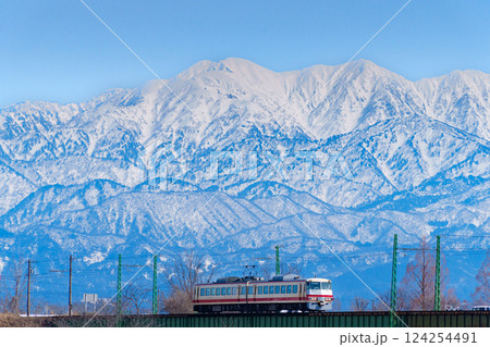 富山地方鉄道と雪の立山連峰 124254491