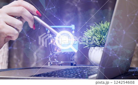 Digital workspace for real estate search and e-commerce with hand using stylus on shopping cart icon, laptop with network graphics 124254608