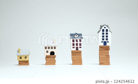 Tiny houses stacked on bricks symbolize rising property prices 124254612