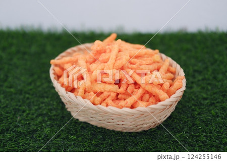 a woven basket filled with crunchy, bright orange snack sticks a woven basket filled with crunchy, bright orange snack sticks 124255146
