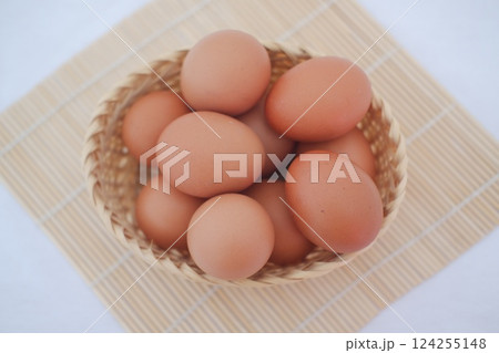 a woven basket filled with fresh brown eggs a woven basket filled with fresh brown eggs 124255148