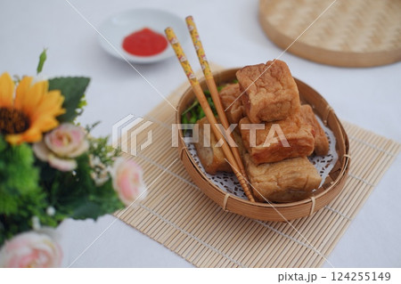 fried tofu arranged in a small woven bamboo basket 124255149