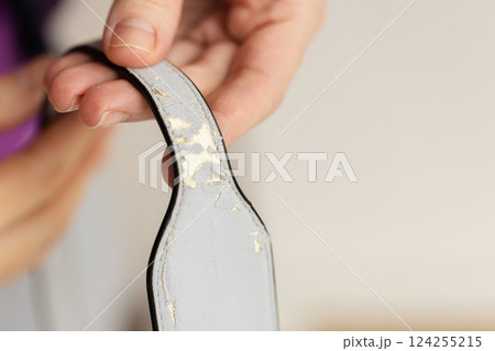 Womans hand holding shabby handle diaper bag. Closeup. Womans hand holding shabby handle diaper bag. Closeup. 124255215