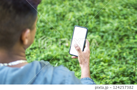 Close up of a man with cell phone in hand, close up of hands with cell phone with white screen, young guy with cell phone in hand with copy space Close up of a man with cell phone in hand, close up of hands with cell phone with white screen, young guy with cell phone in hand with copy space 124257382