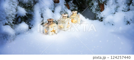 Lanterns in the snow under the Christmas tree 124257440