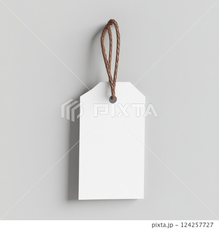 A white tag hanging from a brown cord 124257727
