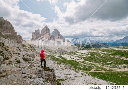 Hiker admires Tre Cime di Lavaredo, Dolomites. 124258243