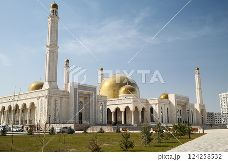 A beautiful central city mosque in Almaty, Kazakhstan, with a golden dome and tall minarets under a clear sky 124258532