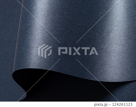 Dark blue paper background with a smooth, glossy texture and metallic shimmer. Cool, rich tones 124261123