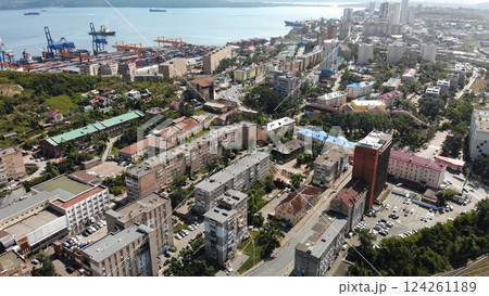 Aerial view of a bustling port city, featuring cargo ships docking near a residential area filled with apartment buildings Aerial view of a bustling port city, featuring cargo ships docking near a residential area filled with apartment buildings 124261189