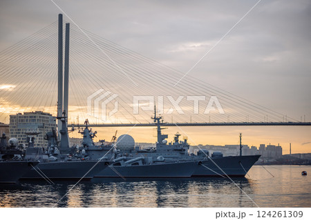Russian navy warships mooring near zolotoy rog bridge during golden sunset, highlighting naval presence in vladivostok harbor 124261309