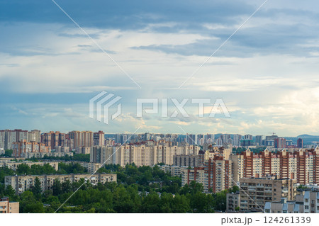 Urban skyline featuring contemporary residential towers rising against soft cloudscape during summer daylight hours 124261339