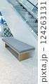 A sleek, modern bench located in a shopping center offers a comfortable spot for visitors to rest. Its minimalist design and neutral tones complement the contemporary interior. 124263131