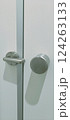 A stainless steel door handle is mounted on a fresh white door, showcasing a clean and modern design. The sleek finish creates a sophisticated look suitable for contemporary interiors. 124263133