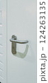 A white door stands against a backdrop of glossy white tiles and black lower wall tiles. The door features a contemporary handle, enhancing the minimalistic decor of the area 124263135
