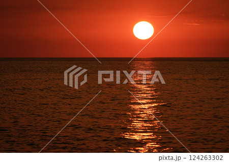 Orange red sunset. Footage of a clear sky and sunlight reflecting on the sea. 124263302