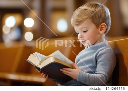 Child Reading Bible in Church with Soft Lighting 124264556