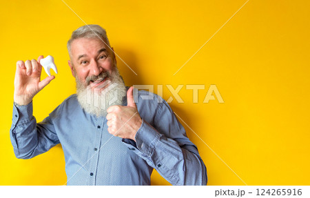 Happy elderly man with a tooth in his hand 124265916