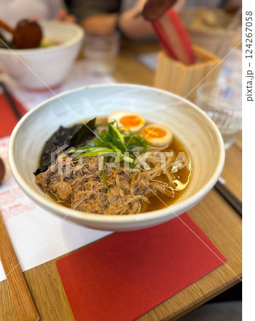 Ramen soup with meat, noodles, egg and pak choi in restaurant. Japanese cuisine Ramen soup with meat, noodles, egg and pak choi in restaurant. Japanese cuisine 124267058