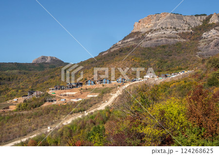 Construction of cottages under the mountain. Construction of cottages under the mountain. 124268625
